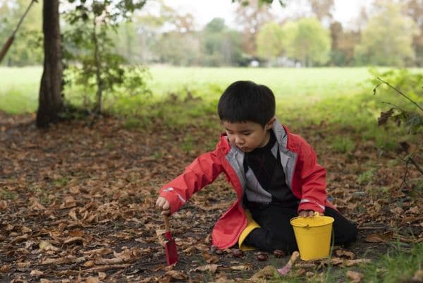 Pupil playing outdoors, at our nature based school located in Morden Hall Park
