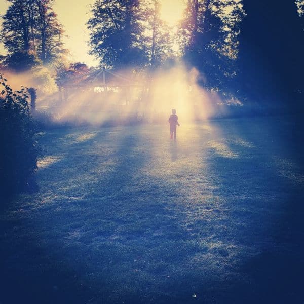 A picture of sunrise, with a child playing at our nature-based school